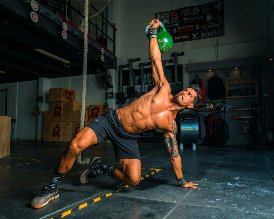 Hombre entrenando con una pesa rusa en un box de entrenamiento funcional