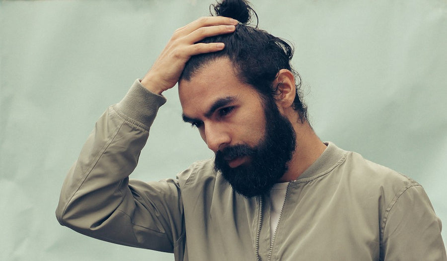 Hombre joven pasándose la mano por el cabello negro