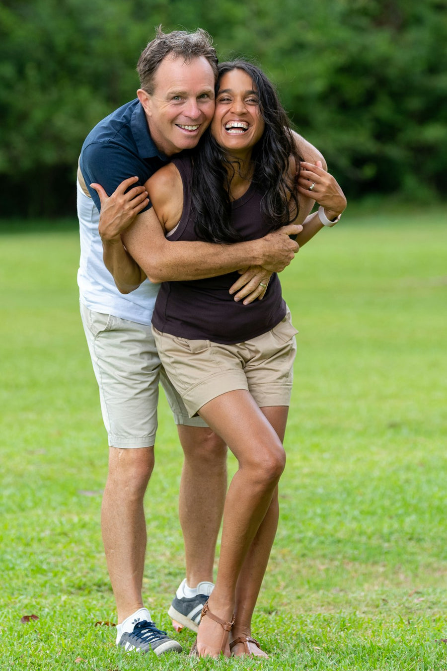 Pareja abrazada y riendo en el pasto