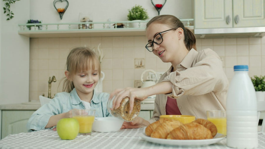 Mamá y su hija desayunando juntas en la cocina