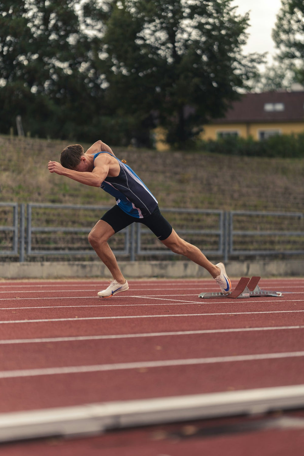 Velocista arrancando desde los bloques de salida en una pista de atletismo